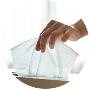 Hand entnimmt ein Taschentuch aus der Box, symbolisiert Allergien und Atemwegsreaktionen.